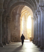 Priest Walking in a long corridor